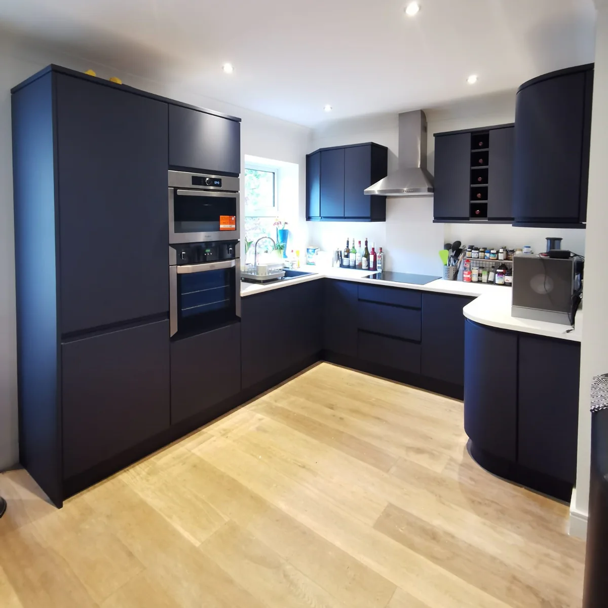 Professional kitchen renovation result showing a matte navy blue interior wrapping on sleek, modern cabinetry.