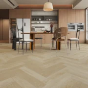 Light oak herringbone laminate flooring in a modern minimalist kitchen and dining area.
